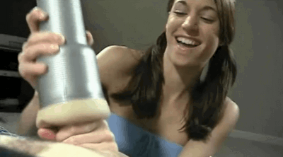 Teen babe giving a pussy handjob with a fuck toy onahole for a hard oiled cock and smiling with a horny face